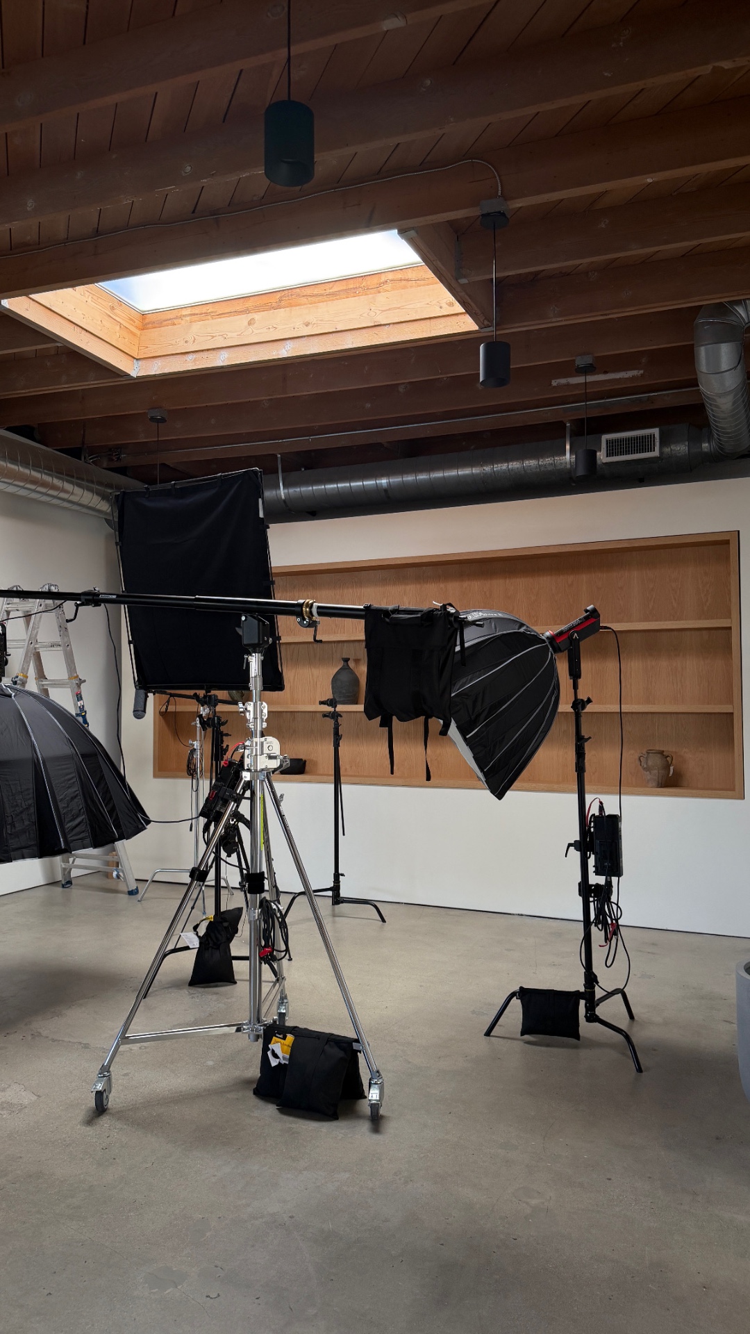 Custom podcast backdrop with inset oak shelving and studio lighting at Intro