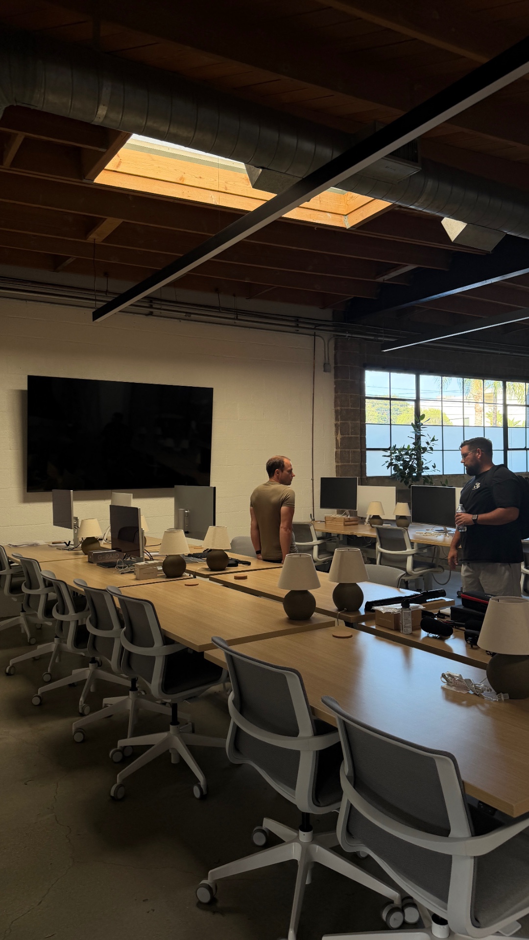 Open desking area at Intro with custom oak workbenches and exposed beams