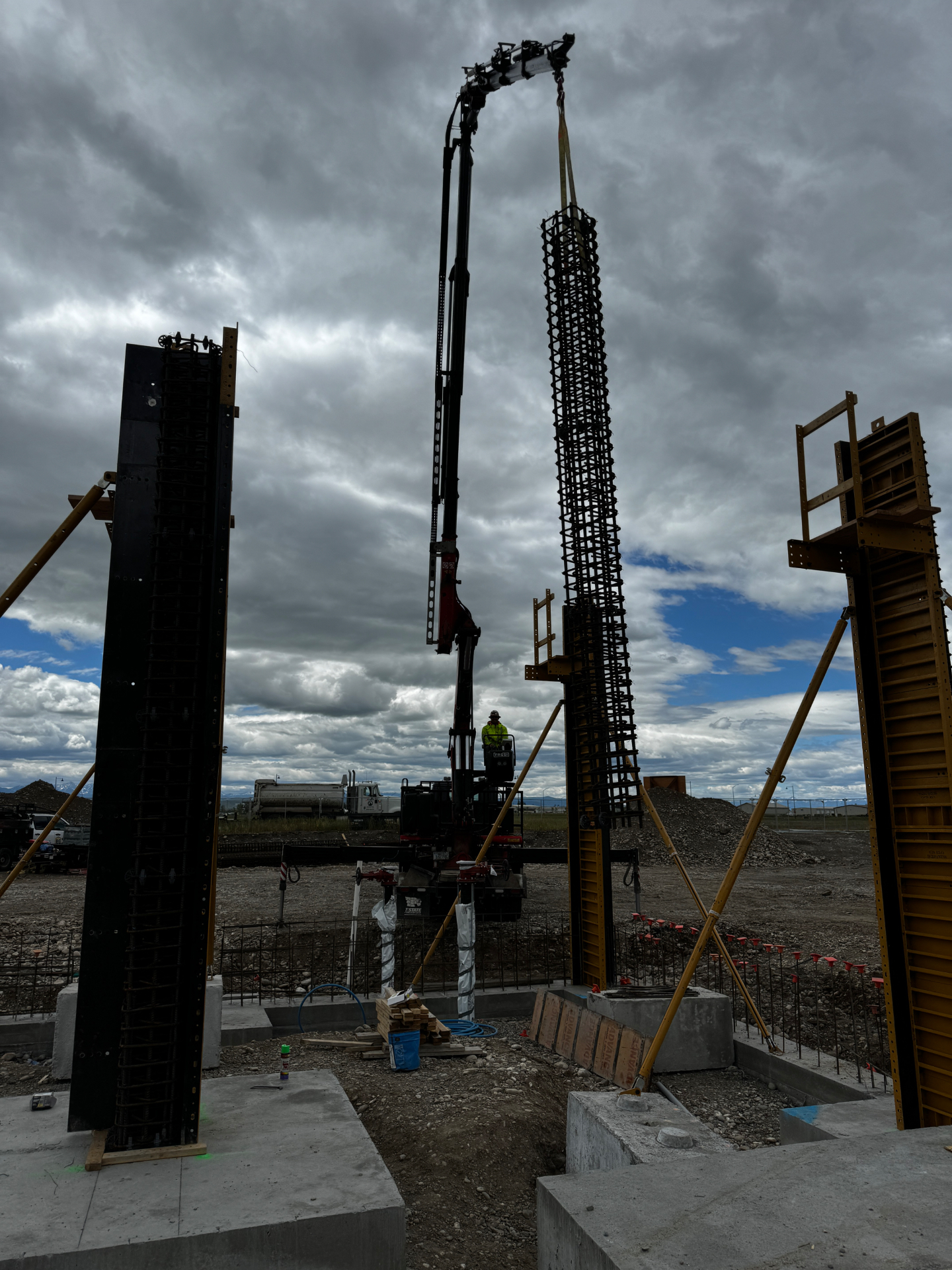 Crane lifting a rebar cage on a job site