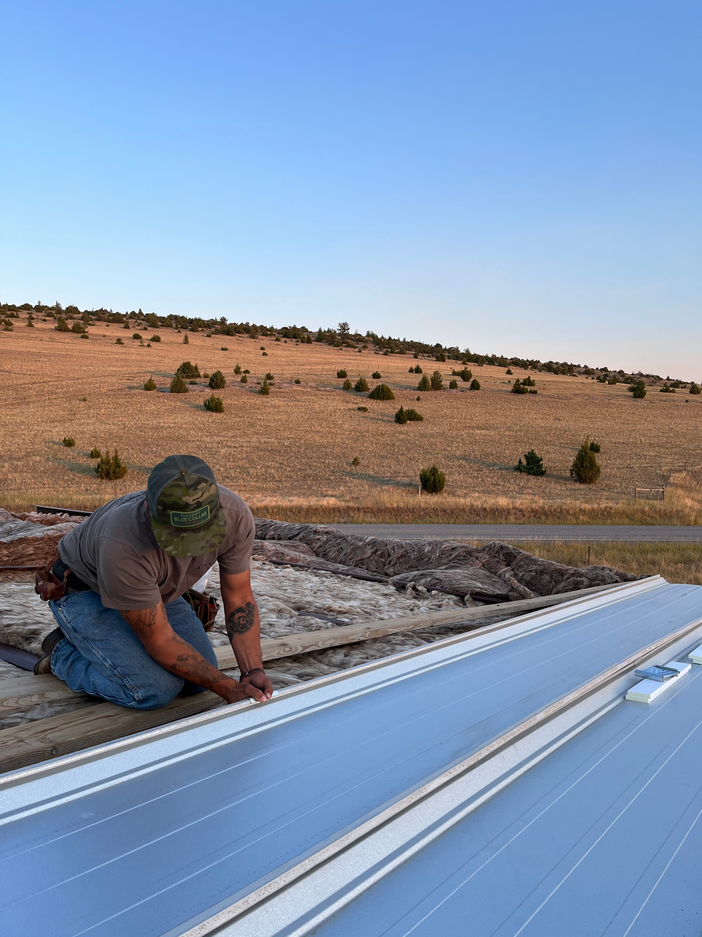 Brock setting standing seam metal roofing in eastern Oregon