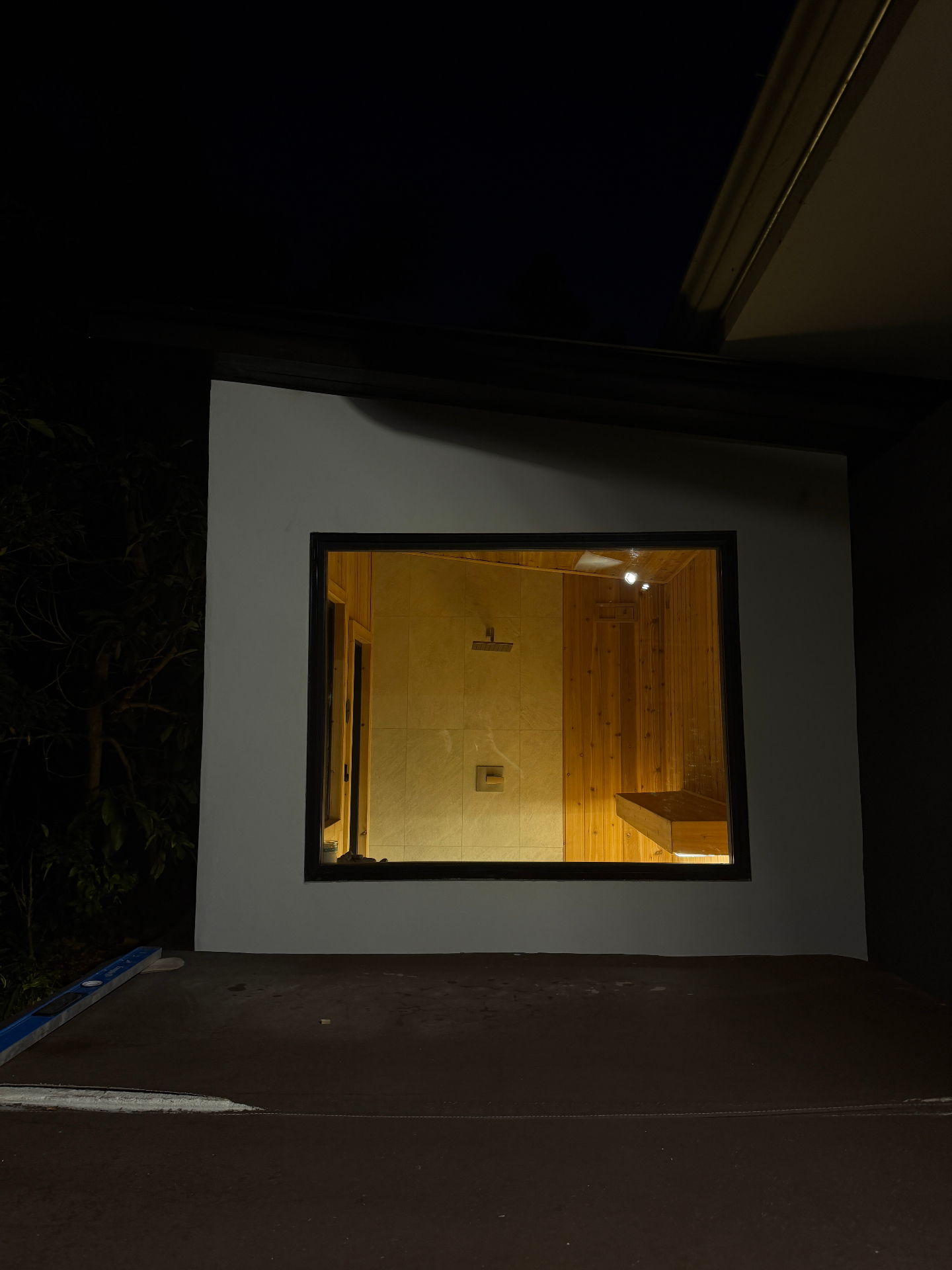 Window detail — view through black-framed window into cedar sauna